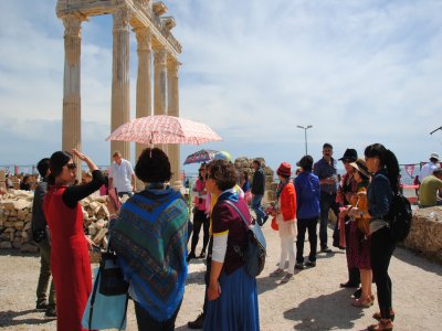 Çinli turistler, şemşiye eşliğinde tarihi ören yerlerini ziyaret ediyor